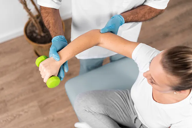 Frau bei Hanteltraining während Krankengymnastik. 